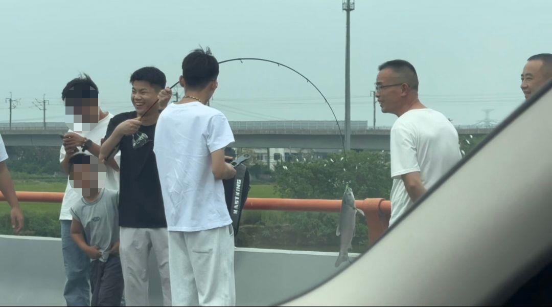 国庆高速堵车男子下车钓鱼，首竿即中大鱼引围观
