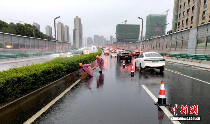 工作人员在清理跨线桥积水