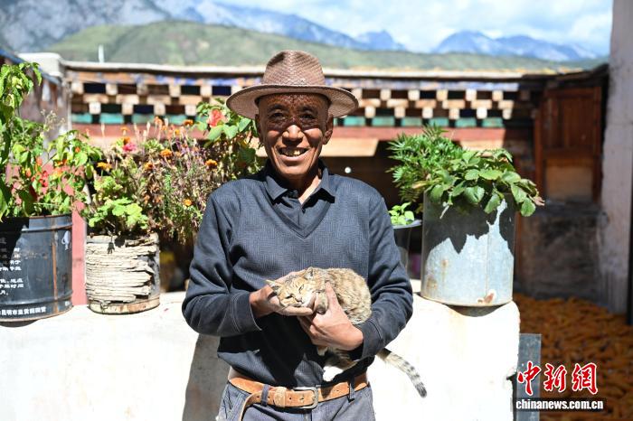 乡城县洞松乡卡心村村民与猫在一起