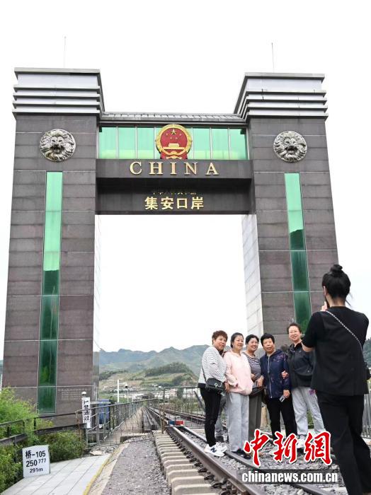 游客在集安铁路口岸国门前合影