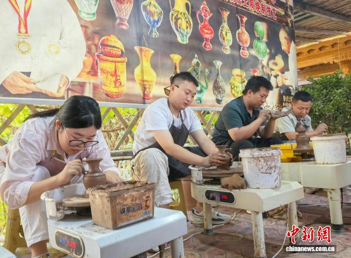 游客在土陶村体验土陶制作