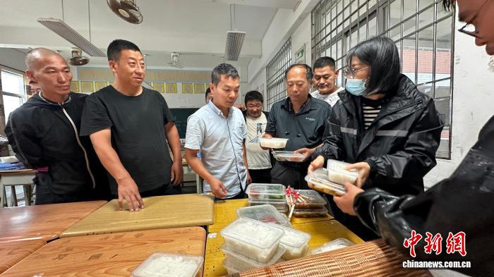 工作人员为滞留安置司乘人员分发盒饭