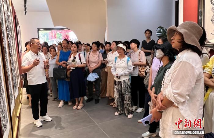 游客参观靴岭尾村刘延山剪纸艺术工作室
