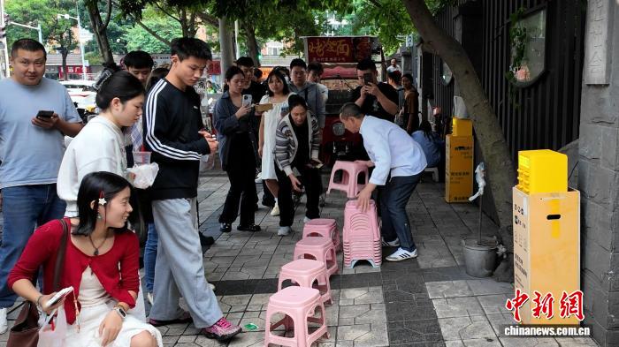 成都蛋烘糕主理人为顾客放置小板凳