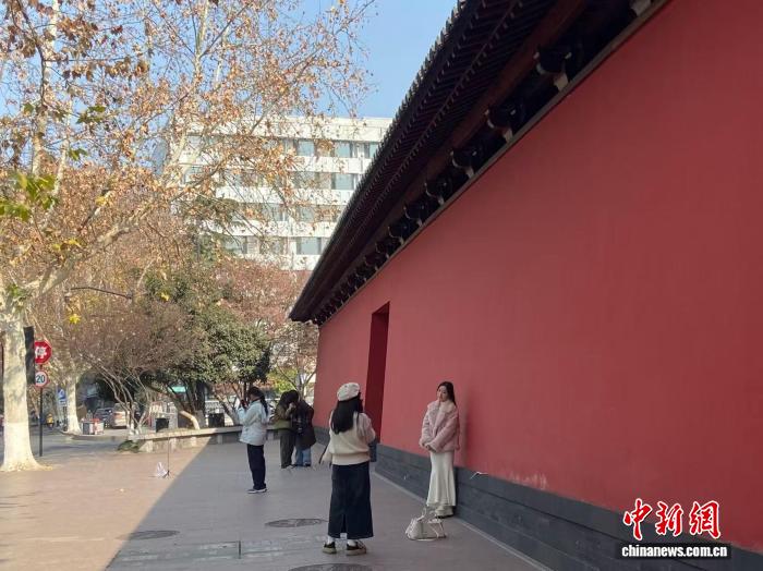 2025年1月，年轻人在杭州南宋德寿宫遗址博物馆“红墙”前拍照。 林波 摄