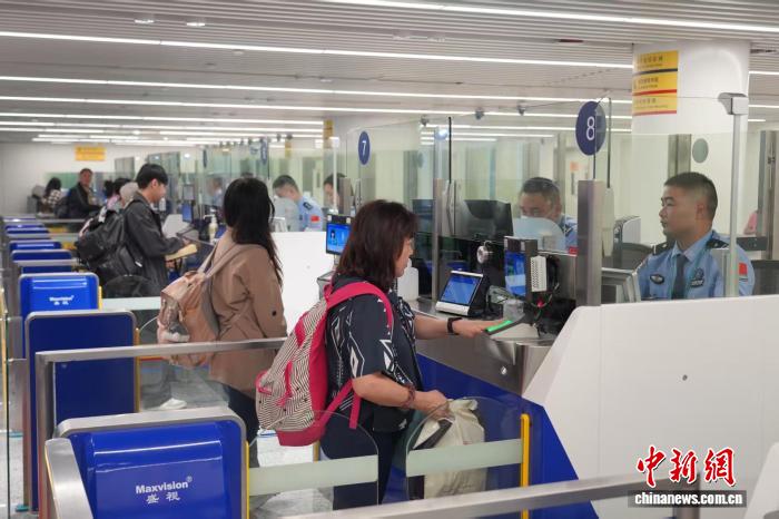 美兰机场边检民警为旅客办理通关手续